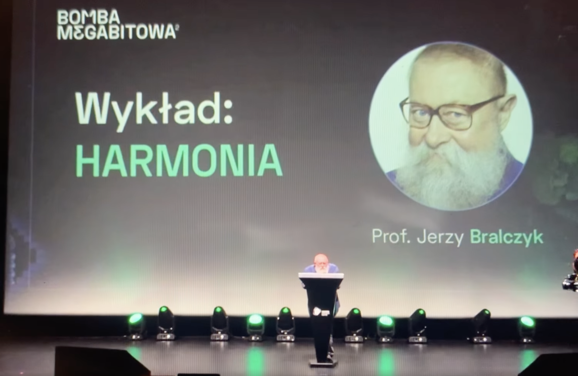 Prof. Bralczyk na scenie, w tle slajd tytułowy „Wykład: Harmonia”